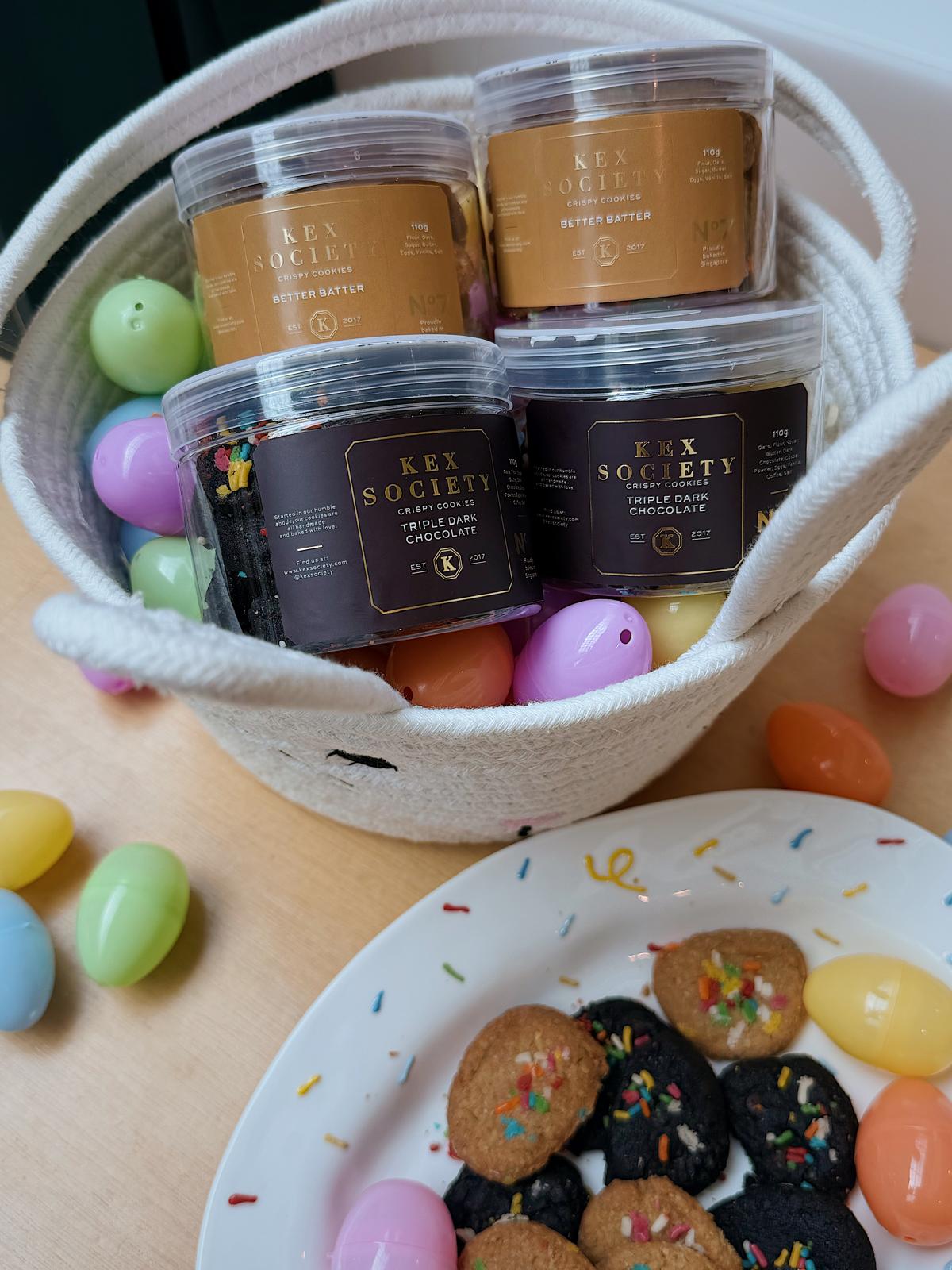 Baskets with Key Society chocolate and Easter eggs on a table with cookies and jelly beans.