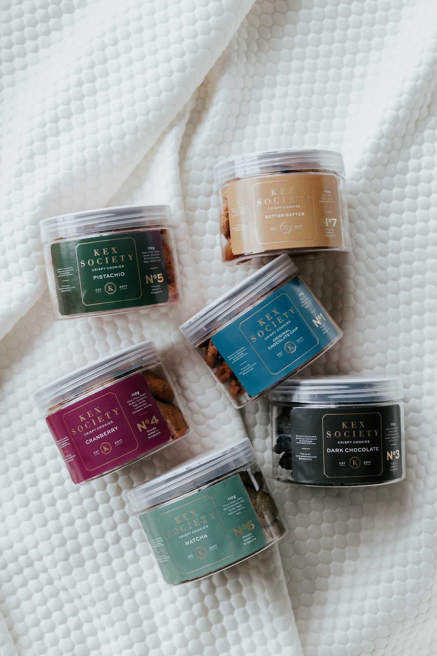 mini bundle of 6 110g crispy kex society cookies ona soft blanket